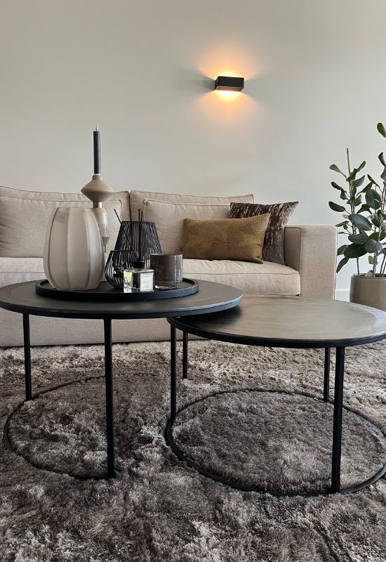 Ronde metalen salontafelset taupe hoogpolig vloerkleed beige hoekbank