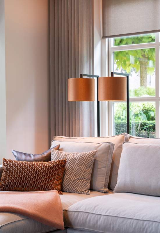 Hoekbank beige met roestoranje kussens plaid en lampenkap